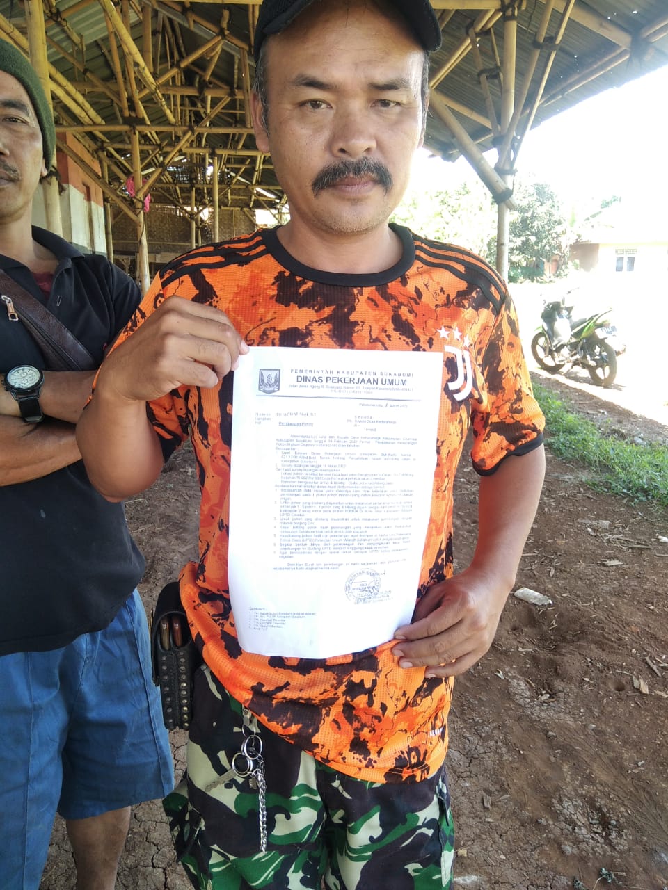 Seorang warga menunjukkan surat dari dinas pekerjaan umum terkait penebangan pohon
